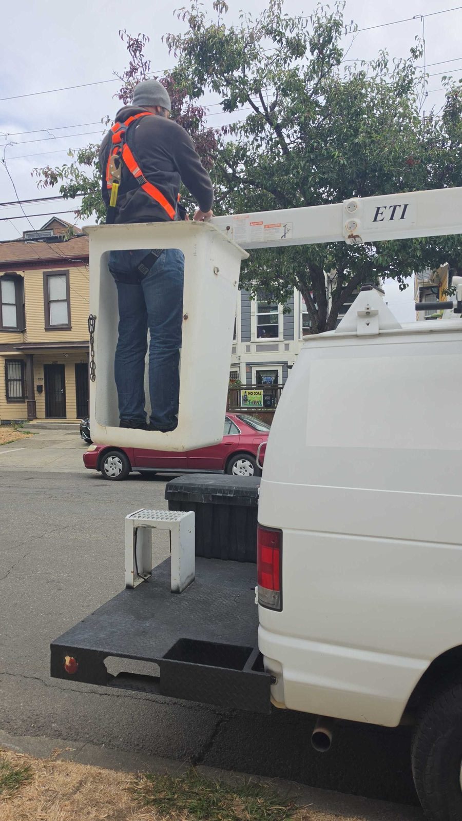 Close-up of a harnessed worker standing in the bucket of the Aerbits bucket van