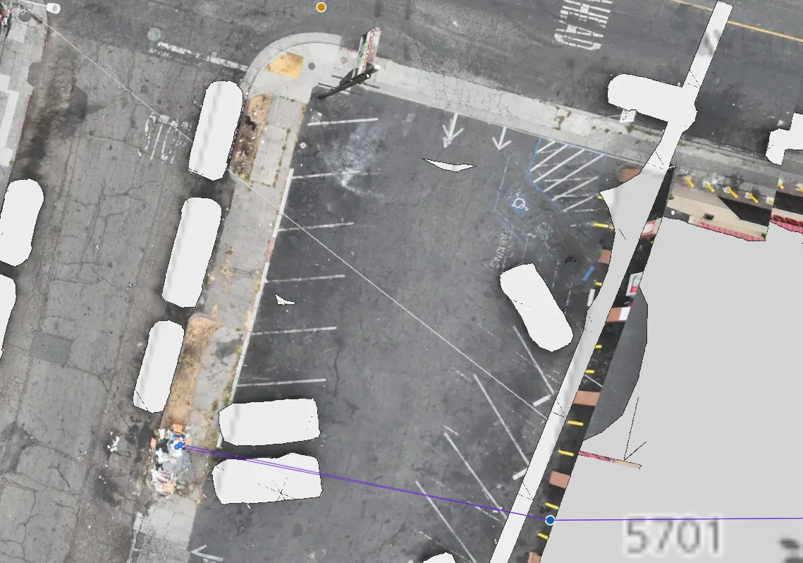 Aerial view along a curb with a purple line running from a geocoded address on the street to a pile of dumping across the way